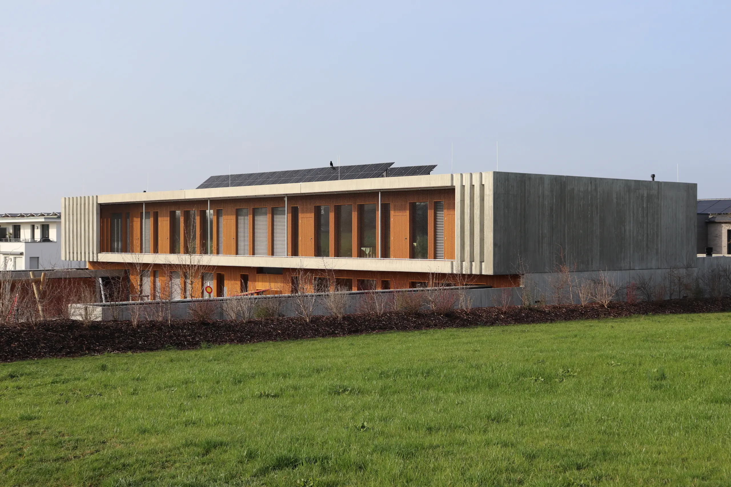 Neubau in Holz-Beton-Bauweise mit Holzfassade und Photovoltaik auf dem Dach